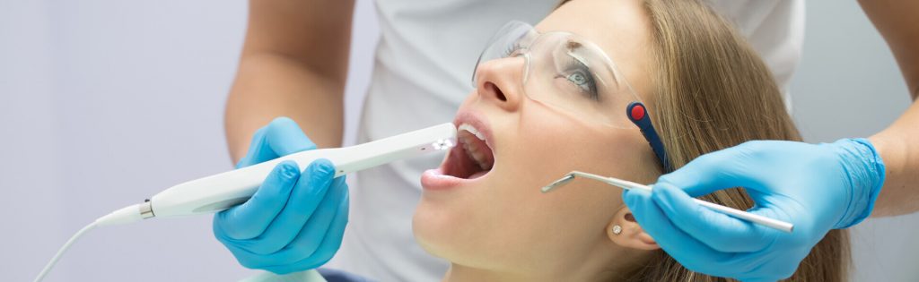 woman getting her teeth examined with dental technology.