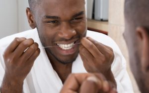 man flossing his teeth