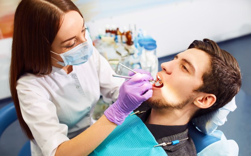 man in a dental chair having his teeth worked on by a dentist