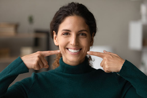 woman pointing at her teeth